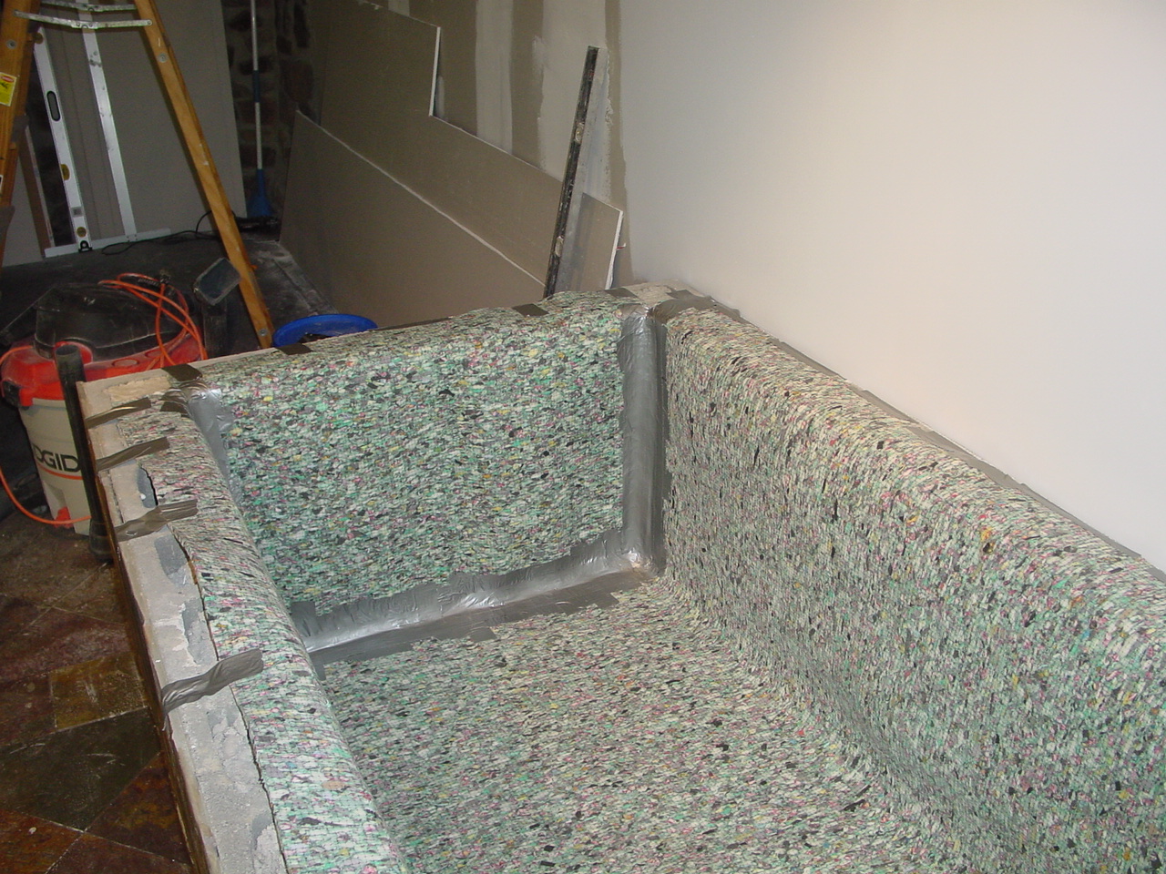 Padding the pond walls before liner